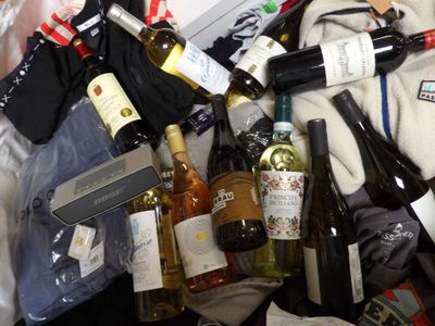 a pile of wine bottles and other items in a suitcase