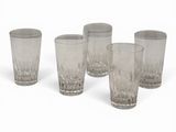 six glasses are lined up in a row on a white surface