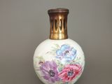 un vase blanc orné de fleurs peintes, posé sur une table