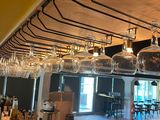 many wine glasses hanging from the ceiling of this restaurant