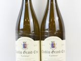 deux bouteilles de vin posées l'une à côté de l'autre sur une surface blanche