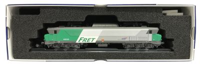 un train vert et blanc dans une boîte, posé sur les rails