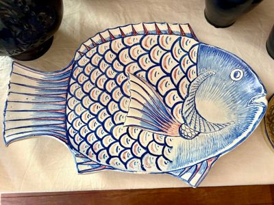 une assiette ornée d'un motif de poisson, posée sur une table