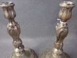 two silver candlesticks that are sitting on a table