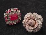 une paire de boucles d'oreilles roses et argentées posées sur une surface noire