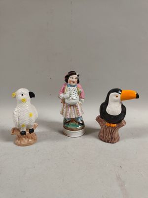 three figurines of people and a bird on a stump