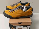 Des baskets jaunes et noires sont posées sur une boîte en carton