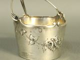 a silver bucket with flowers on it sitting on a table
