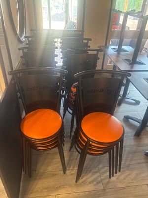 several orange chairs are lined up in a row in a restaurant