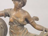 a statue of a woman sitting on top of a clock