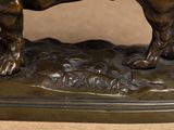 bronze statue of a bull on a base with a brown background