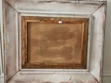 an old picture frame sitting on top of a wooden table