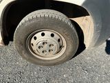 un camion blanc avec un pneu crevé, garé dans la rue