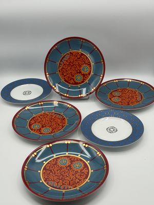 six blue and red plates with designs on them sitting on a table