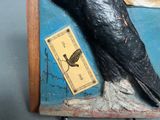 a statue of a black bird with a tag on it ' s neck
