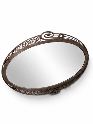 un miroir rond orné d'un motif décoratif sur le pourtour