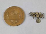 a gold medal and a silver medal on a white surface