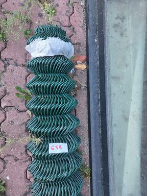 a piece of green chain link fence laying on the ground