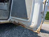 a white truck that has a door open on the side of the road