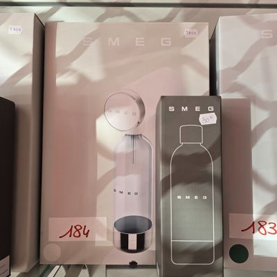 Plusieurs boîtes de parfums sont posées sur une étagère dans un magasin.