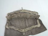 a silver purse that is sitting on a table