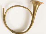 an antique brass french horn on a white background