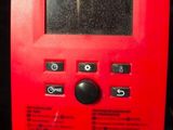 a close up of a red electronic device on a table