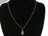 un collier en or avec un pendentif en perle autour du cou d'un mannequin