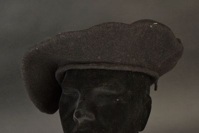 a black hat on a mannequin head on a table
