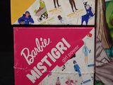 three barbie dolls are sitting on top of a black table