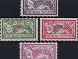 four different colored stamps on a black surface