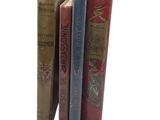 trois livres posés l'un à côté de l'autre sur une surface blanche