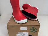 une boîte sur laquelle est posée une paire de bottes de pluie rouges