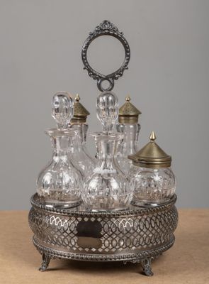 une carafe en argent et en verre posée sur une table en bois