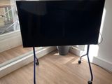 un téléviseur à écran plat sur un support dans le coin d'une pièce