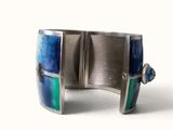 silver cuff bracelet with blue, green, and blue glass inlays