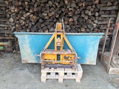 un tas de bois derrière une palette, avec une fourche