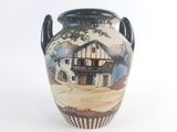 a vase with a picture of a house on it