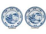 une paire d'assiettes bleues et blanches ornées d'un paysage