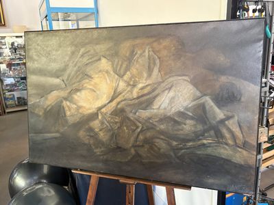 un tableau représentant une femme allongée sur un lit, posé sur un chevalet