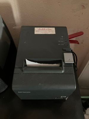une petite imprimante posée sur un bureau, à côté d'un ordinateur