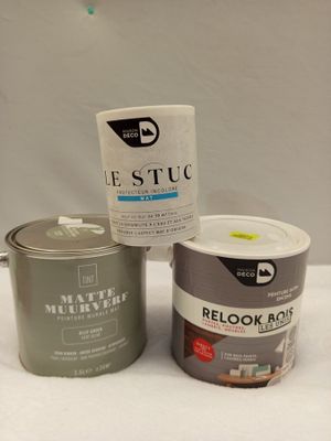 deux pots de peinture posés sur une table à côté d'un bidon de peinture