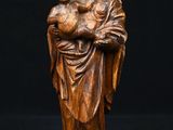 a wooden statue of a woman holding a child