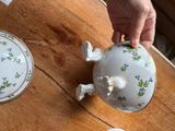 a person holding a teapot on a wooden table