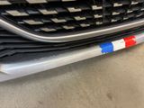 a close up of the grille of a car with a red, white, and blue sticker on it