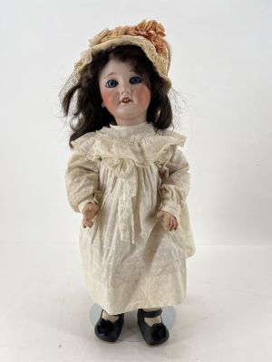une image représentant une poupée avec un chapeau et une robe, sur fond blanc