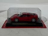 a red car in a clear case on a white surface