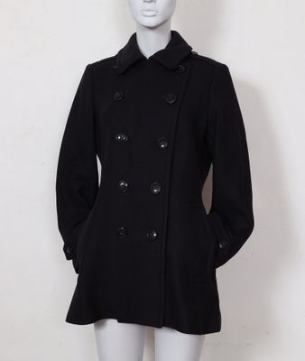 le mannequin porte un manteau et un chapeau noirs