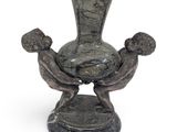 a statue of two people holding a vase on a pedestal