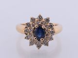 a yellow gold ring with a blue sapphire and white diamonds